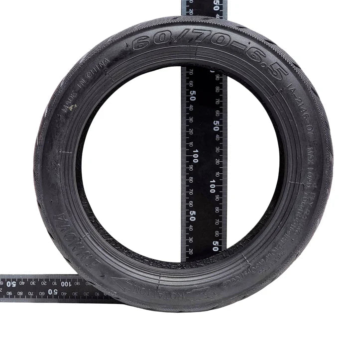 Tire with a ruler showing its size on a white background