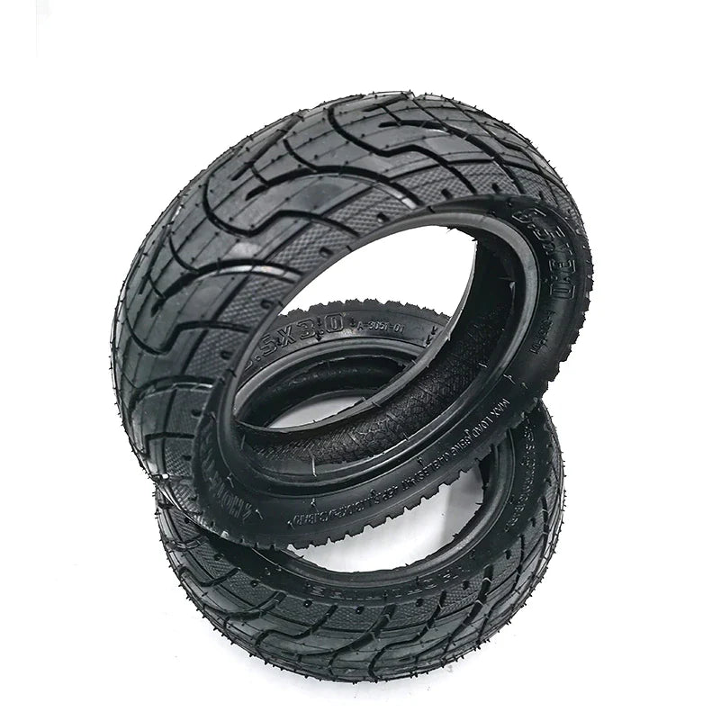 Three black tires with tread patterns on a white background