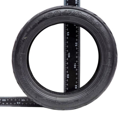 Tire with a ruler showing its size on a white background